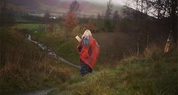 Katharine, shamanic practitioner walking through valley on drum